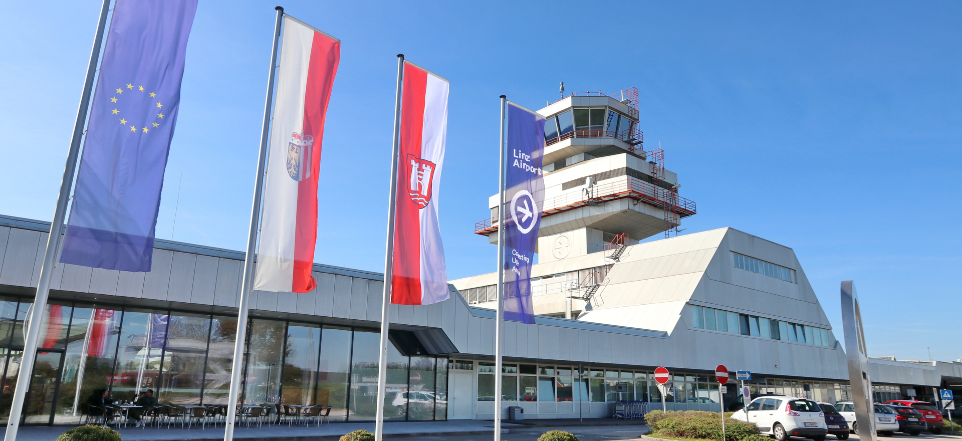 Vorderfront Flughafen mit Tower und Fahnen | © Flughafen Linz